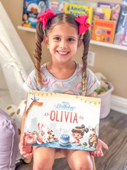 Girl holding a personalised Birthday book by Hooray Heroes