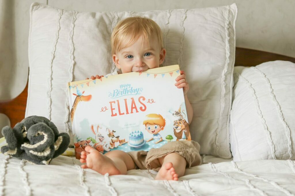 A little boy holding a book called Happy Birthday Elias. Happy Birthday Jesse. Hooray Heroes personalized children's book - a perfect birthday present for kids.
